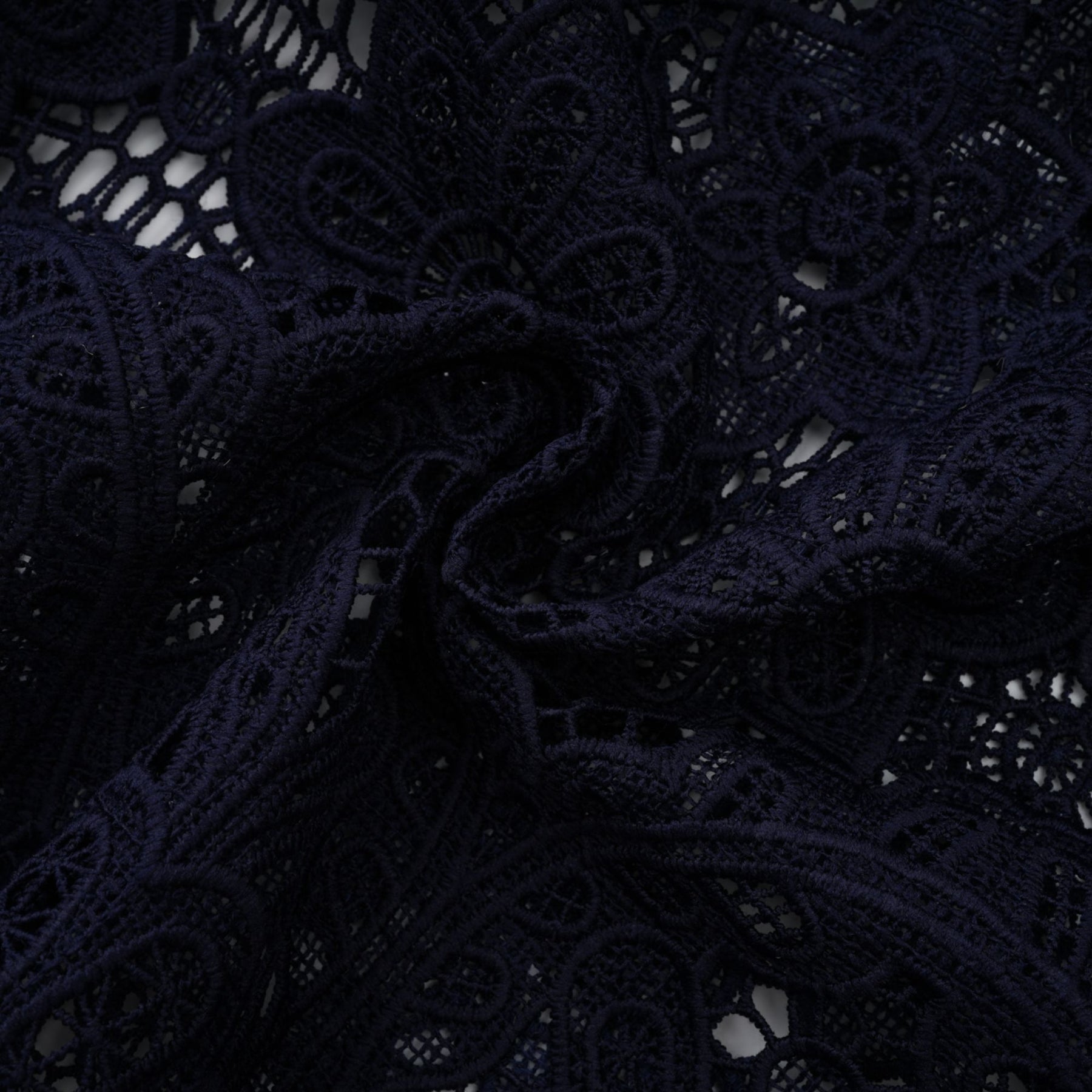 A dark blue midi dress with floral crochet lace pattern and a fitted silhouette