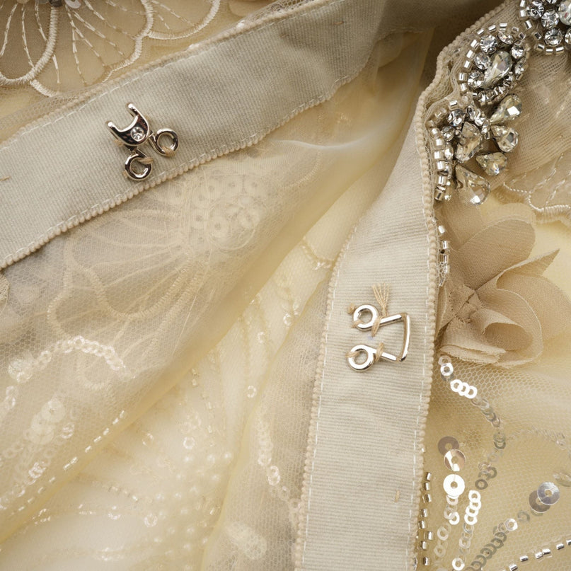 A delicate sheer jacket with floral beaded embellishments on organza fabric creating a luxurious and lightweight appearance