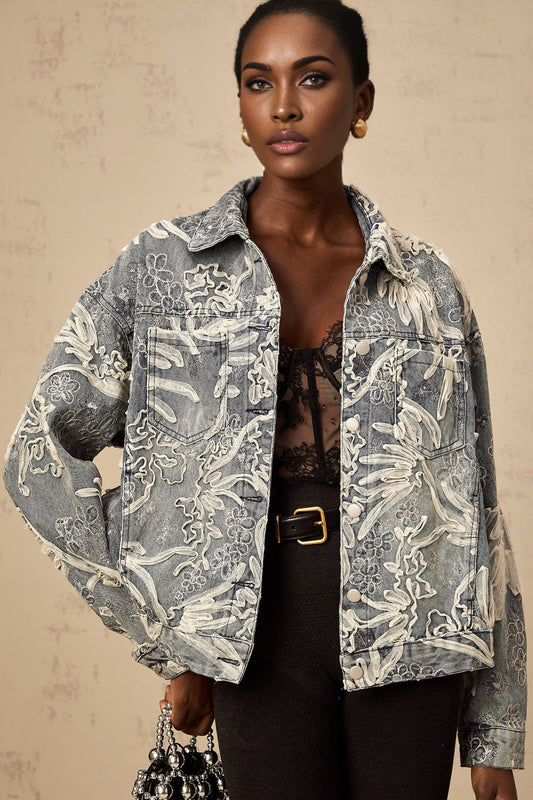 A denim jacket in blue with sequined flower embroidery on the fabric