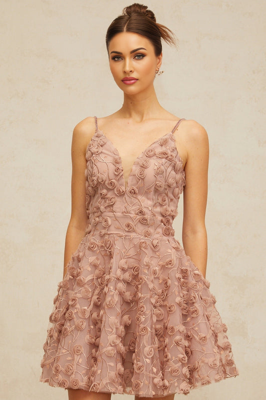 A dusty pink mini dress with flounced hem and rose appliques adorning the fabric