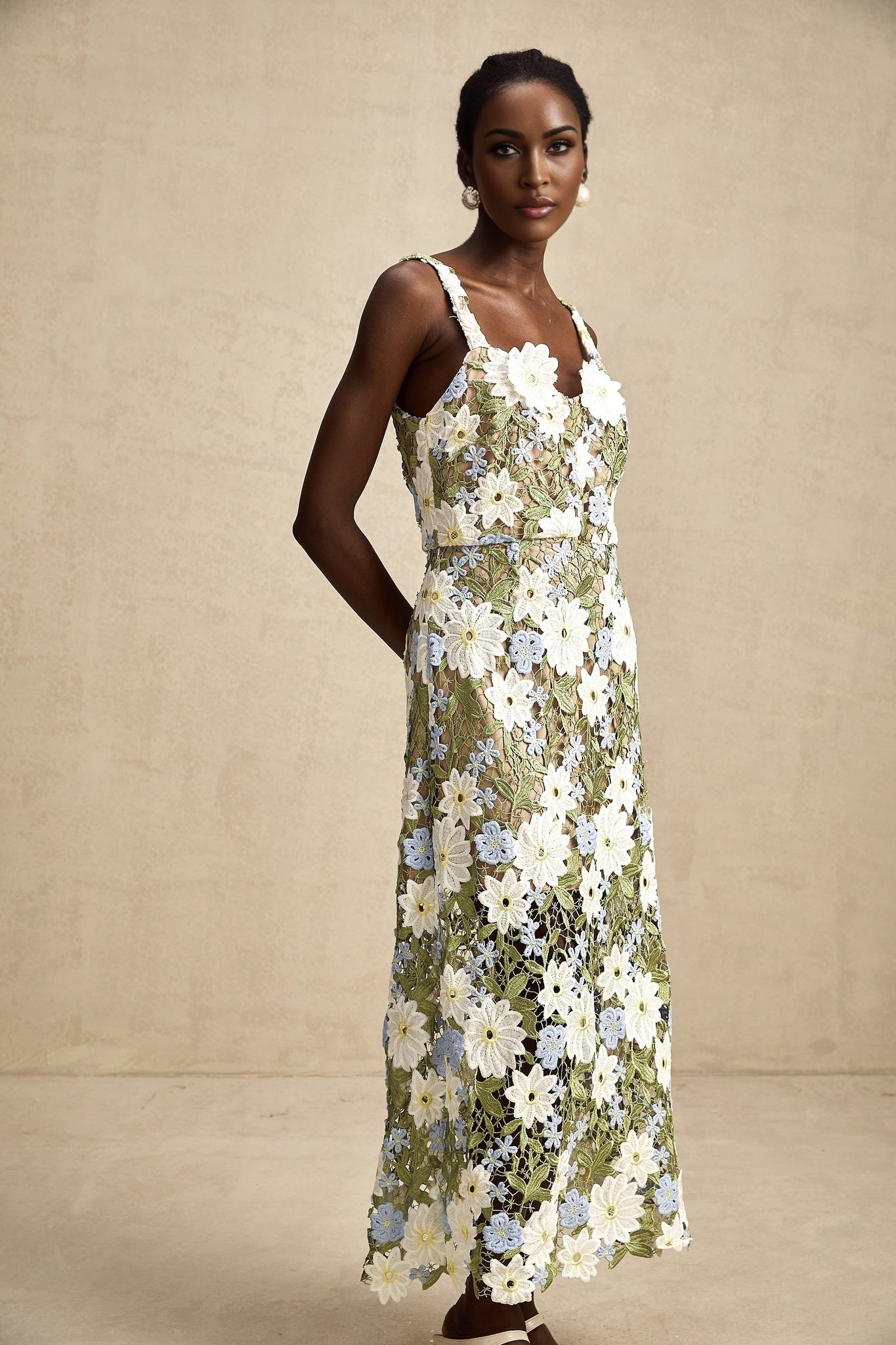 A feminine midi dress with floral embroidery and hollowcarved details featuring a delicate pattern throughout the fabric