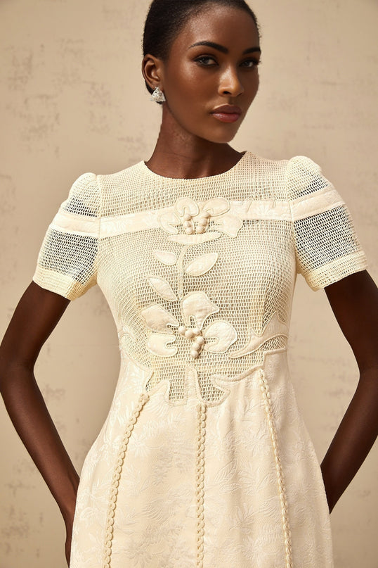 A feminine midi dress with floral embroidery and openwork details featuring a Diane style design