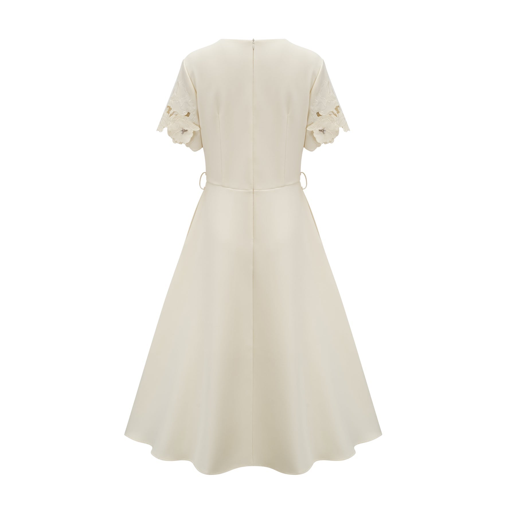 A flared midi dress in neutral tones featuring floral appliqué details with a touch of orange
