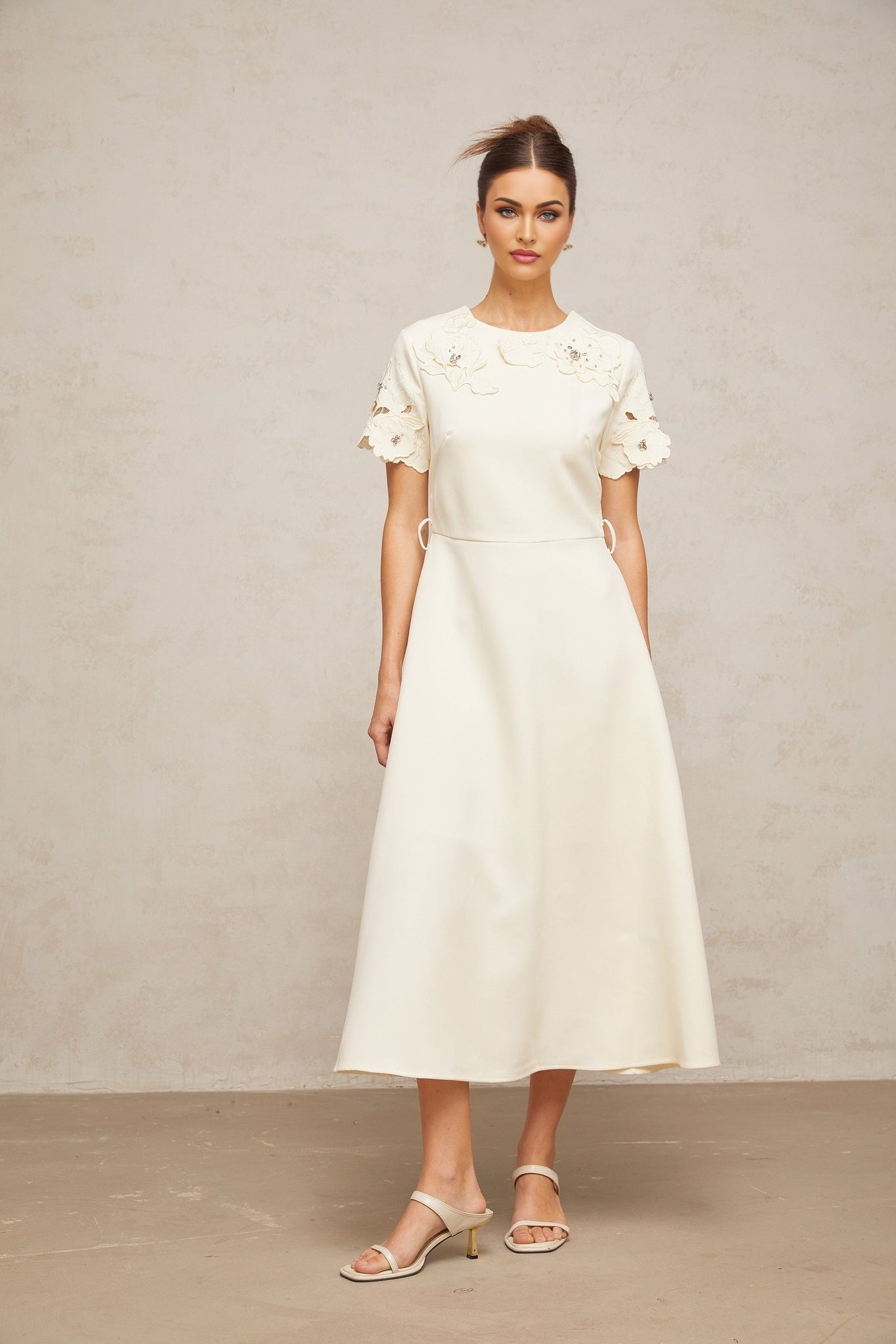 A flared midi dress in neutral tones featuring orane floral applique details