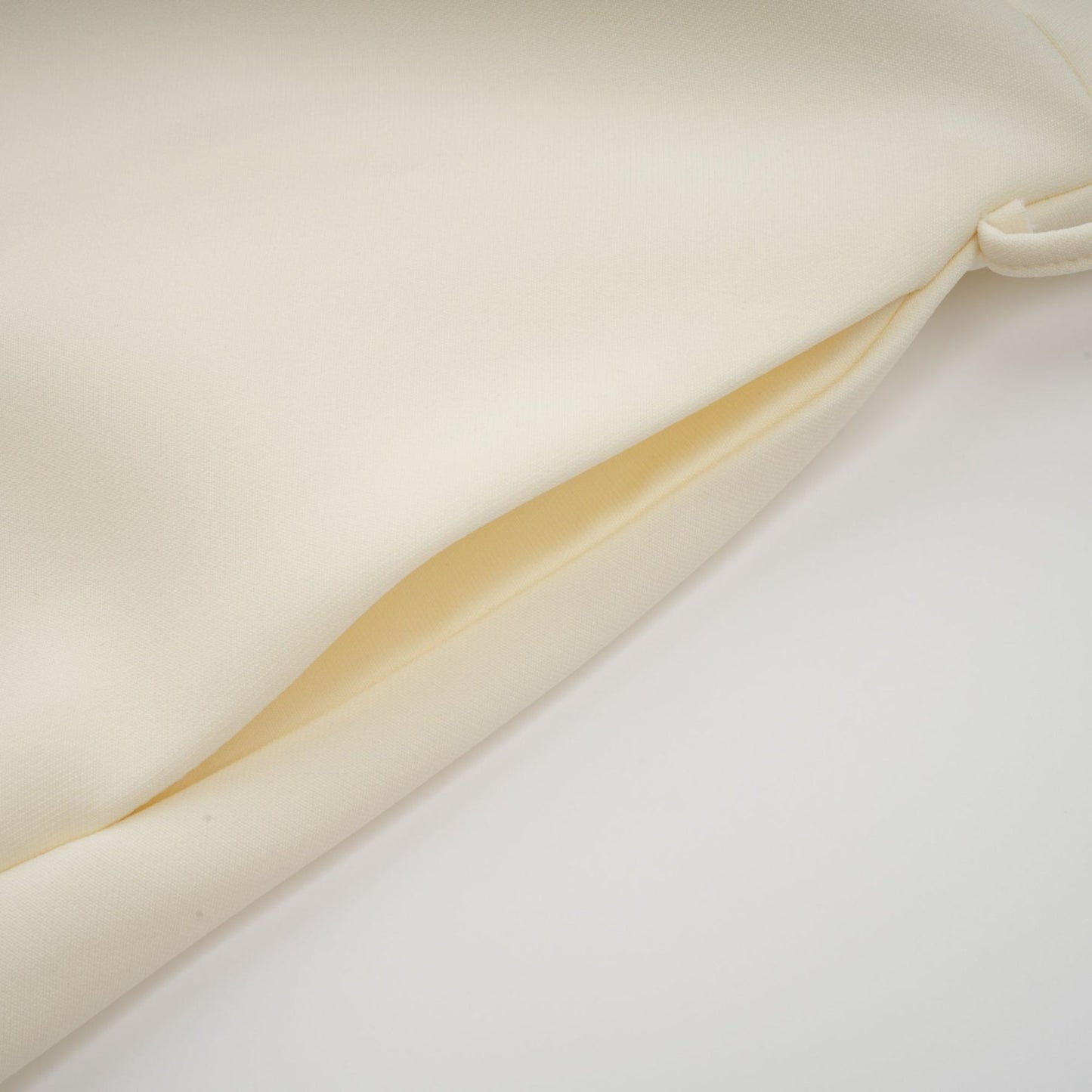 A flared midi dress in neutral tones featuring orange floral appliqués with a feminine silhouette and delicate detailing