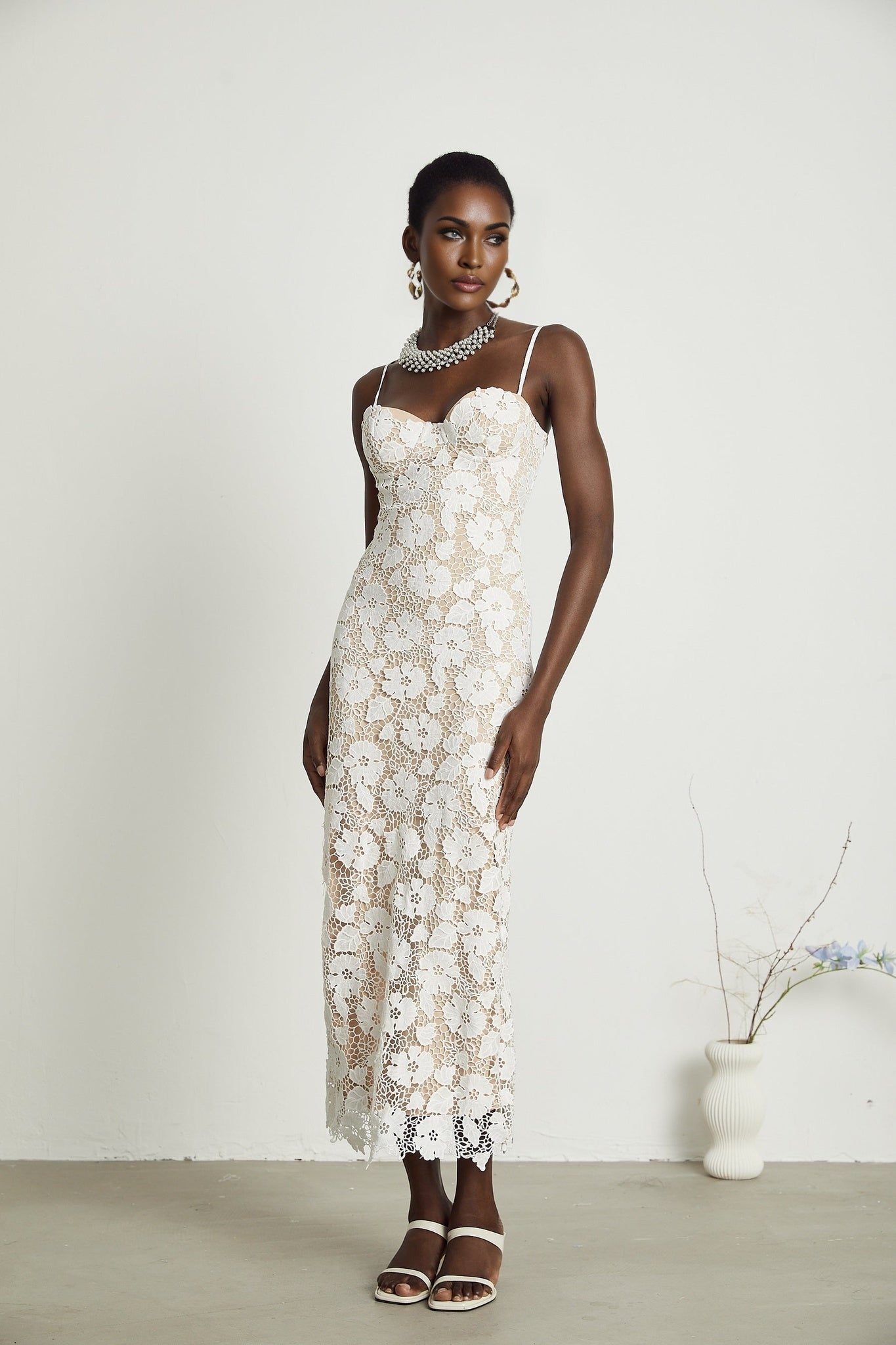 A floral embroidered midi dress in a feminine style with delicate flower stitching on a light colored fabric