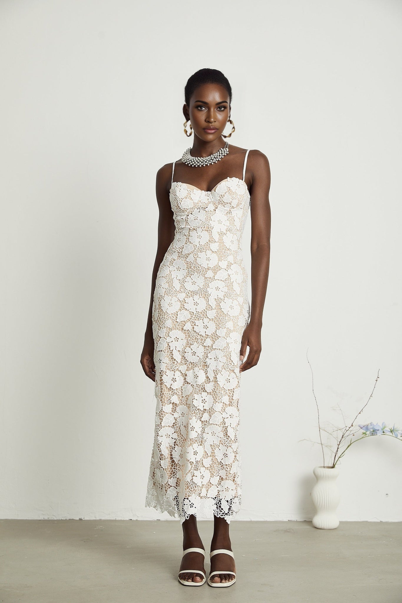 A floral embroidered midi dress in a Florence style featuring delicate stitched flower patterns on a lightweight fabric with a flowing silhouette and feminine details