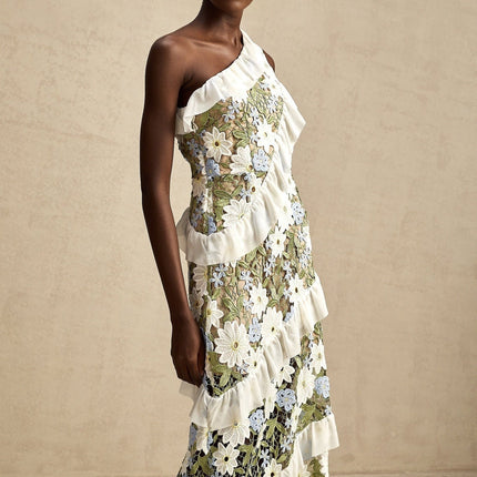 A floral embroidered midi dress named Clemence with a delicate pattern on a light colored fabric