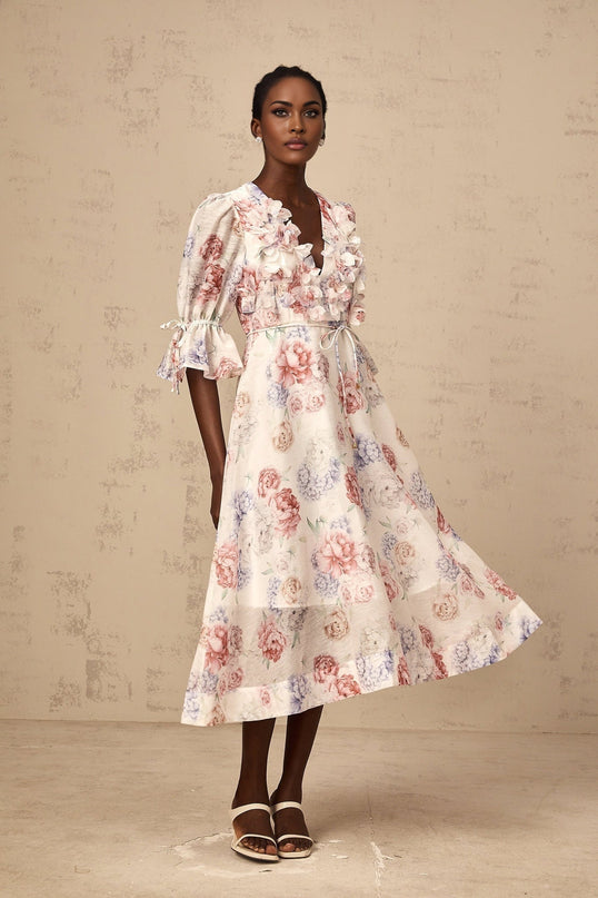 A floral midi dress with a 3d petal print design featuring a vibrant pattern on a flowing silhouette