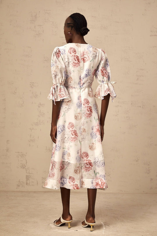 A floral midi dress with a 3d petal print pattern named Tea featuring a vibrant and dimensional floral design on the fabric