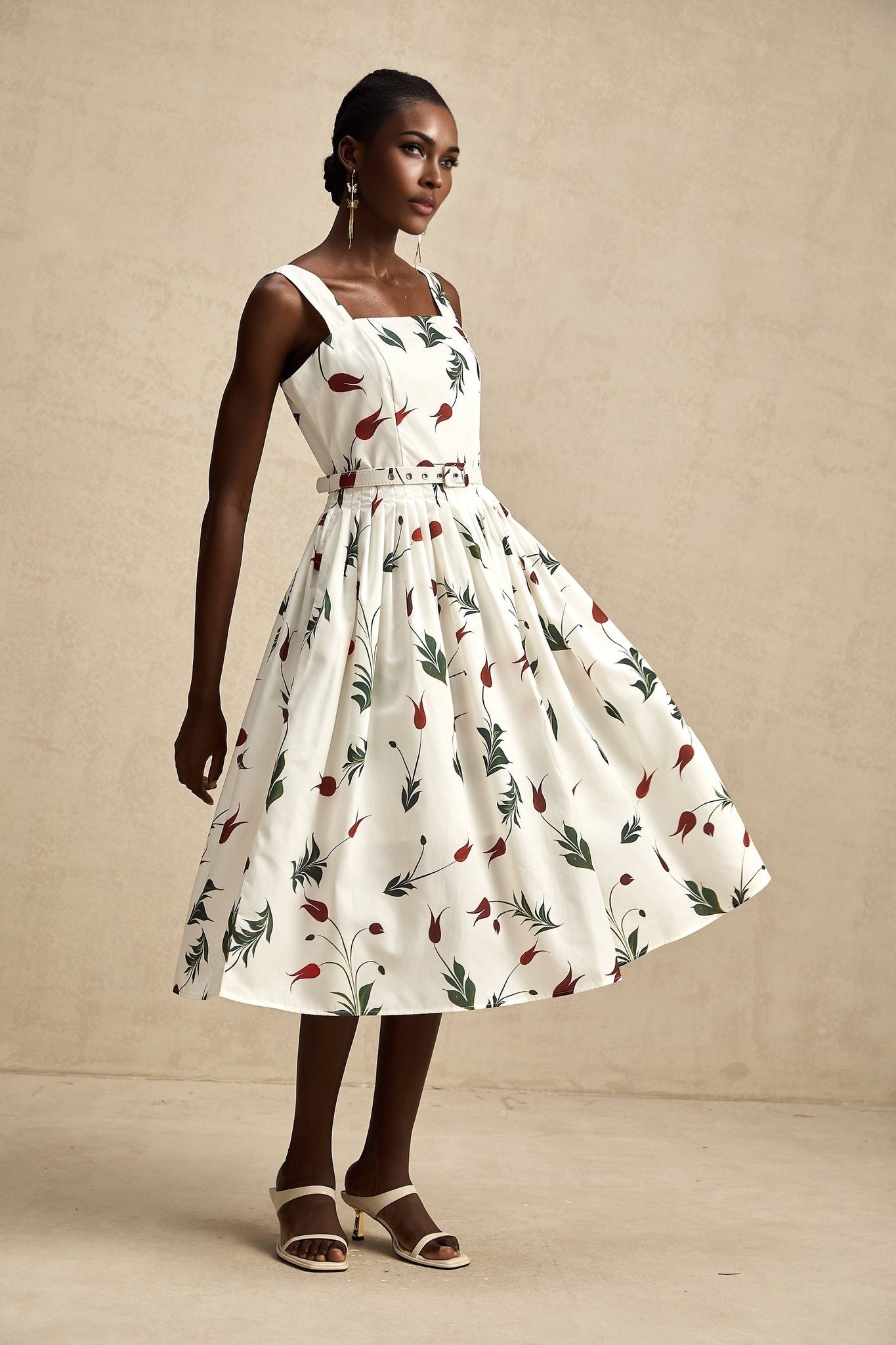 A floral print midi dress with a white background and colorful flower pattern featuring long sleeves and a flowy skirt