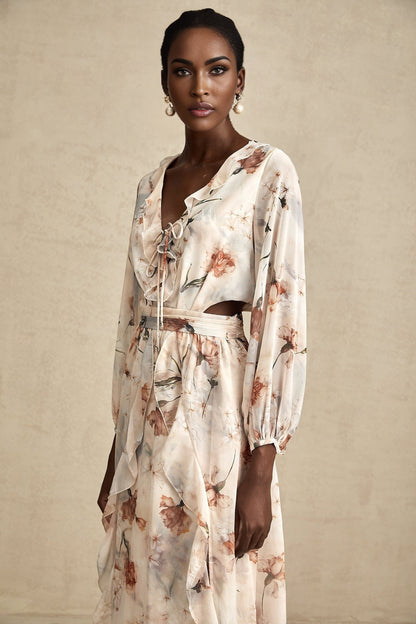 A floral print midi dress with an open waist design featuring a colorful pattern on a light background The dress has a feminine silhouette with a flowing skirt and likely includes details such as short sleeves or straps