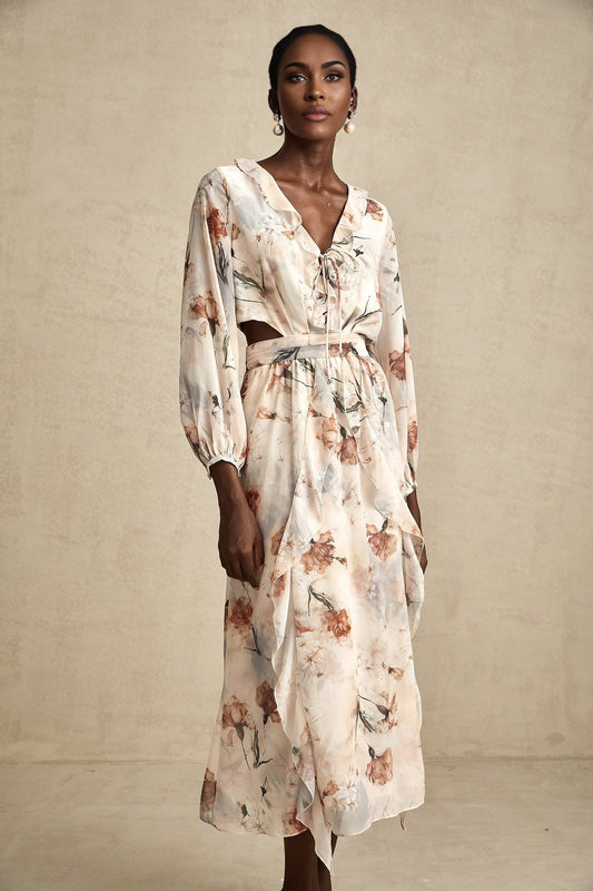 A floral print midi dress with an open waist design featuring a colorful pattern on a light background The dress has a flowing silhouette and appears to be made of lightweight fabric suitable for warmer weather