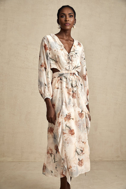 A floral print midi dress with an open waist design featuring a colorful pattern on a light background The dress has a flowing silhouette and appears to be made of lightweight fabric suitable for warmer weather