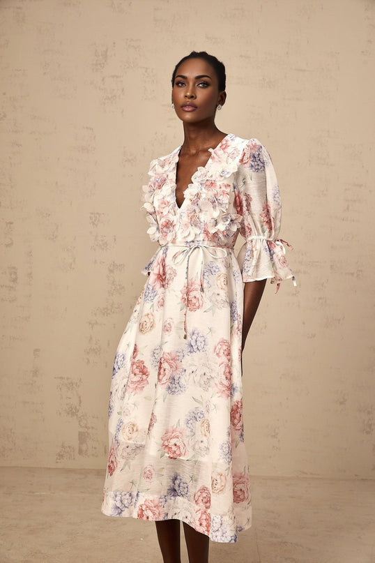 A floral print midi dress with threedimensional petal details featuring a vibrant pattern on a lightweight fabric with a flowing silhouette