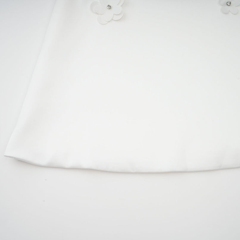 A floral print mini dress with a vibrant pattern featuring colorful faux flowers on a light background short sleeves and a fitted silhouette