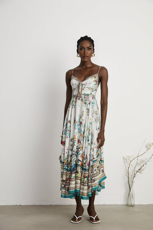 A floral printed midi dress with decorative elements inspired by Philippine design featuring a colorful pattern and embellishments on a flowing silhouette