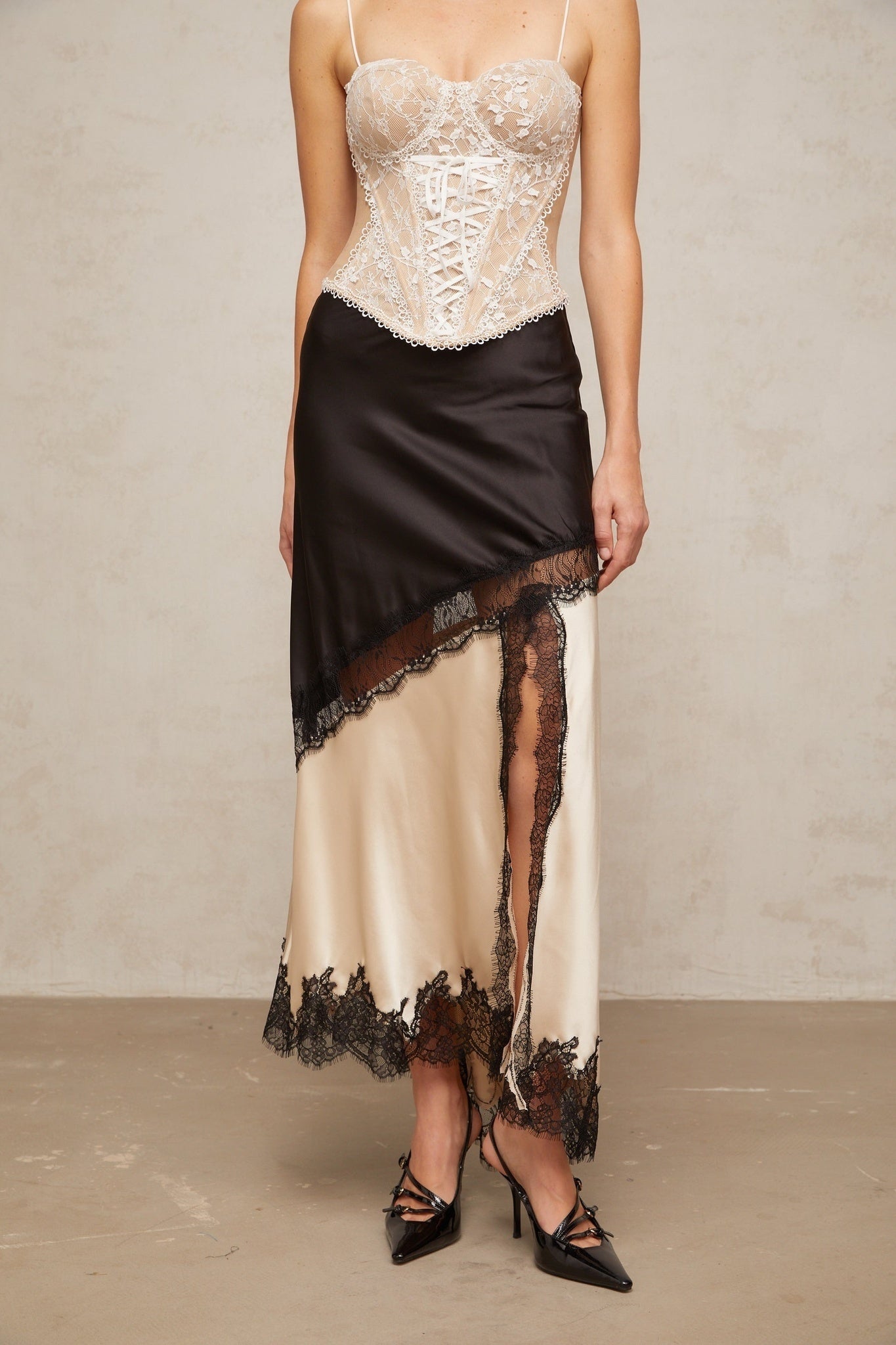 A flowing satin skirt with an asymmetric hem featuring delicate lace panels Raphaelle design in elegant fabric with contrasting textures
