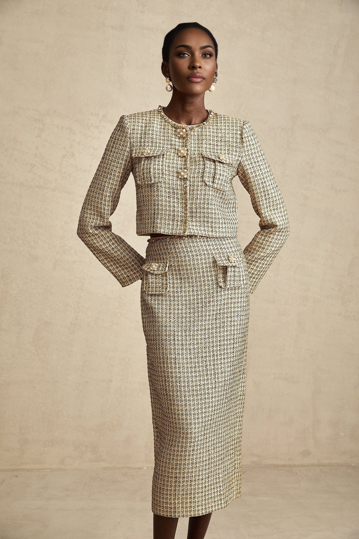 A gold tweed jacket and matching skirt set adorned with sequins for a sparkly elegant look