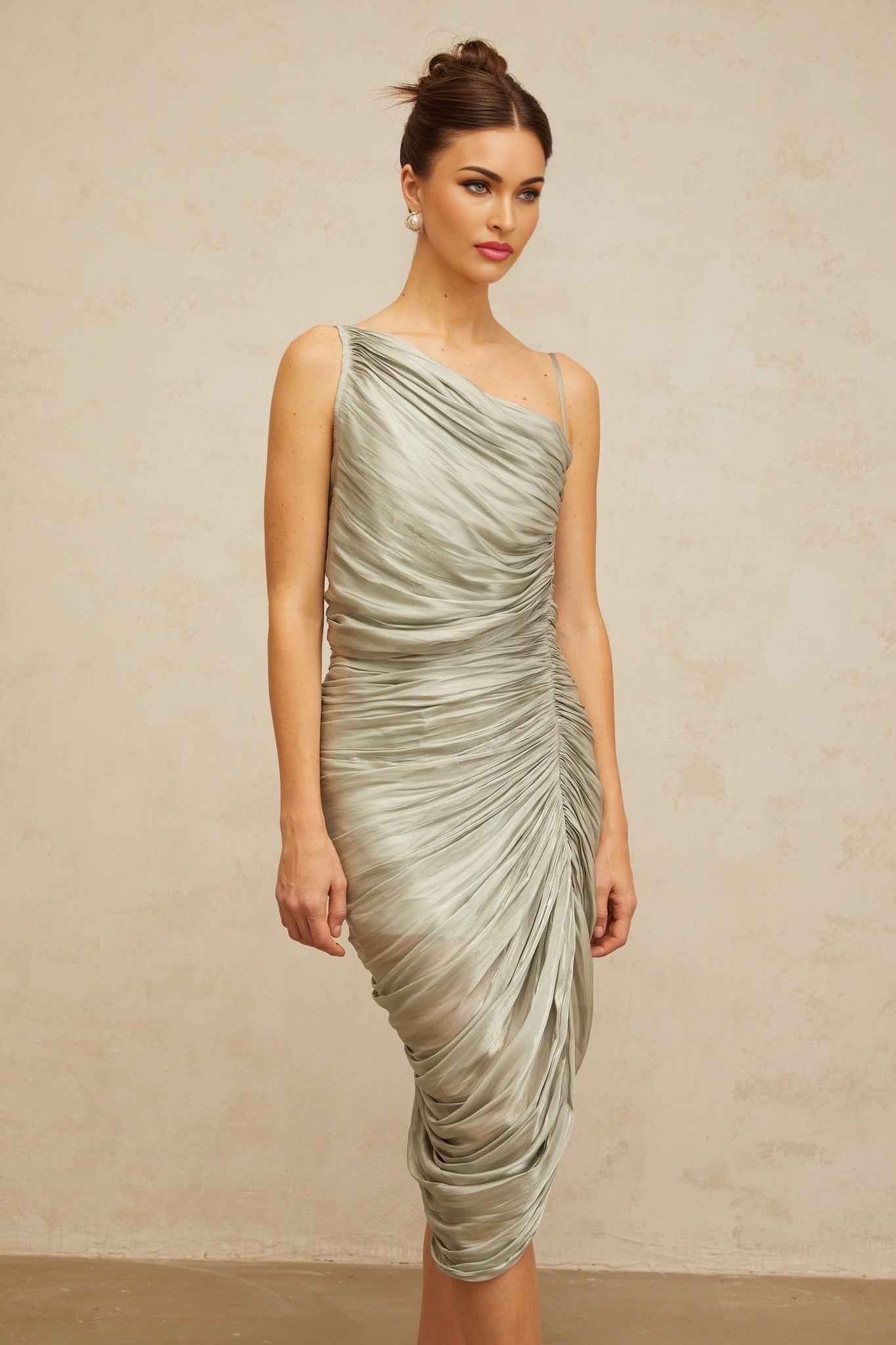 A grayishgreen glossy midi dress with ruched detailing shown on a model against a plain background