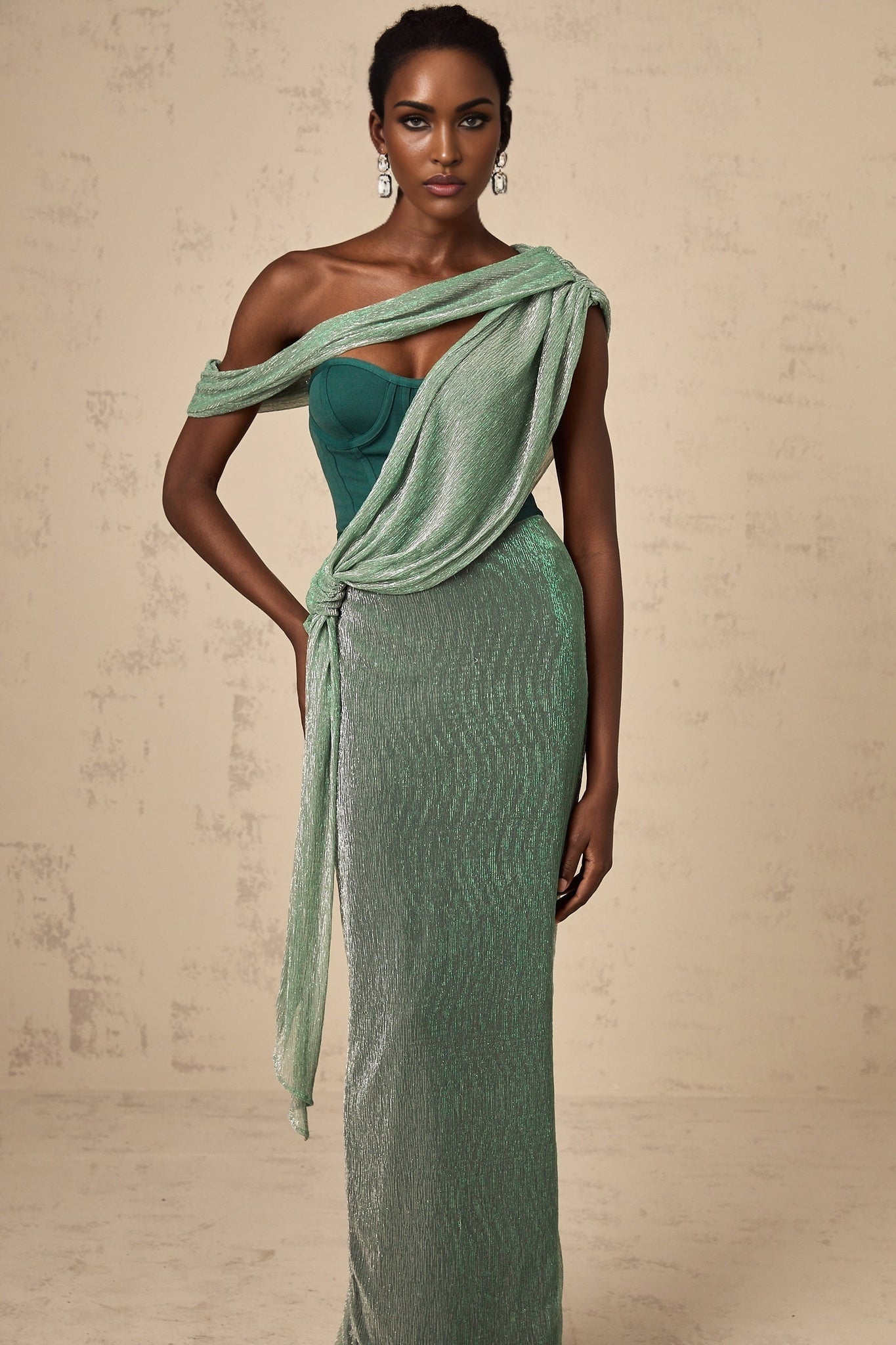 A green maxi dress with corset bodice featuring ribbon design details and long flowing skirt