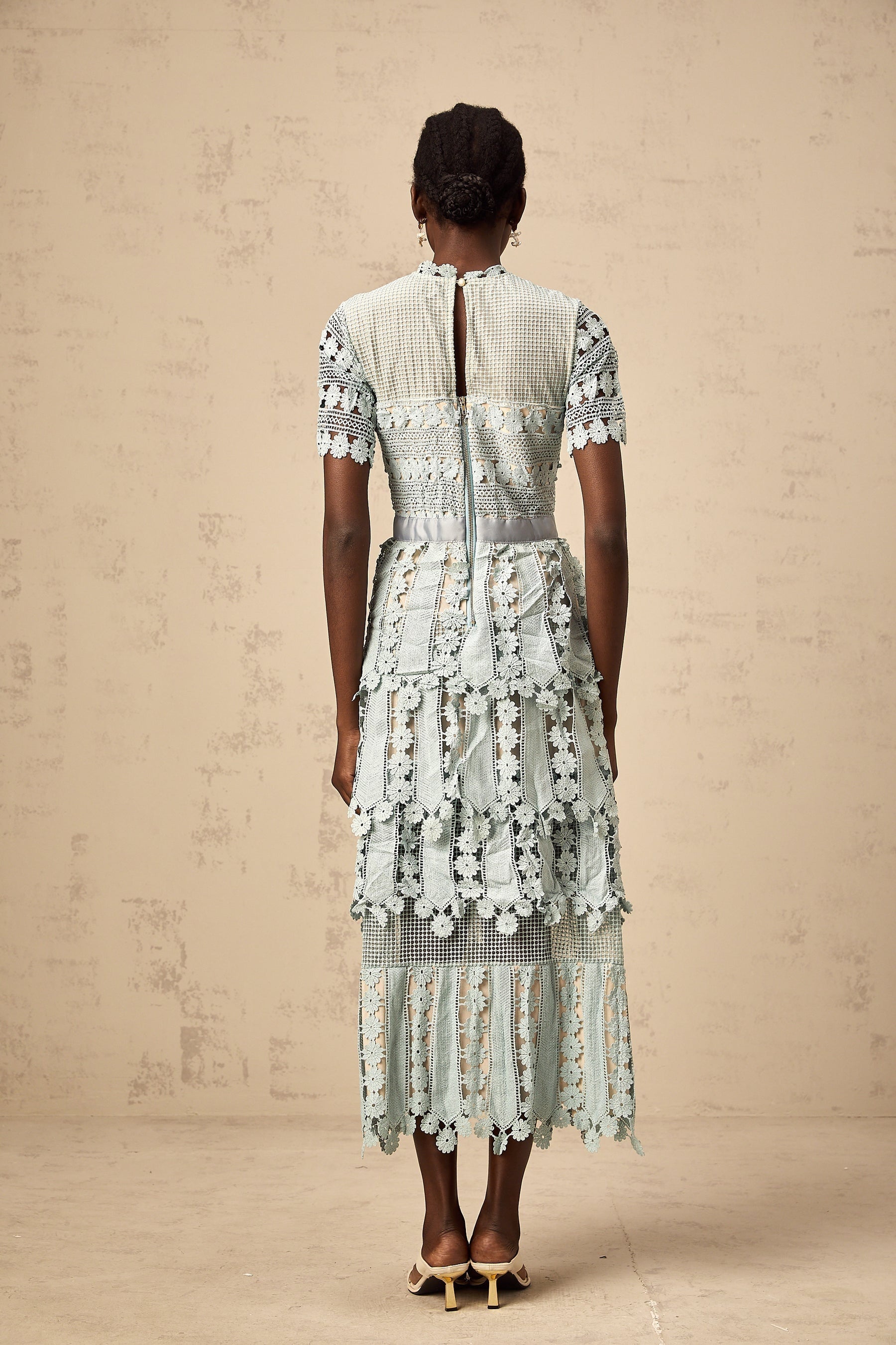 A green midi dress with floral embroidery details featuring a design inspired by ocean themes
