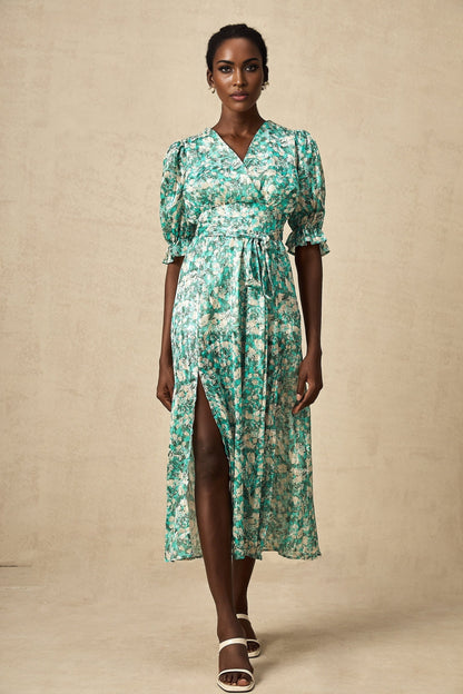 A green midi dress with floral print and high slit featuring a feminine silhouette