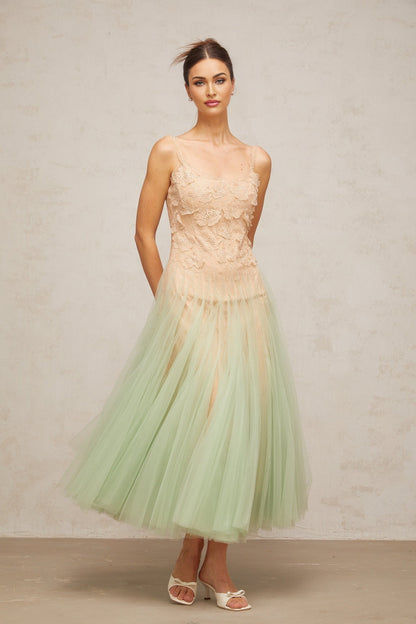 A green midi dress with lace panelling and tulle fabric featuring a slim silhouette and delicate details