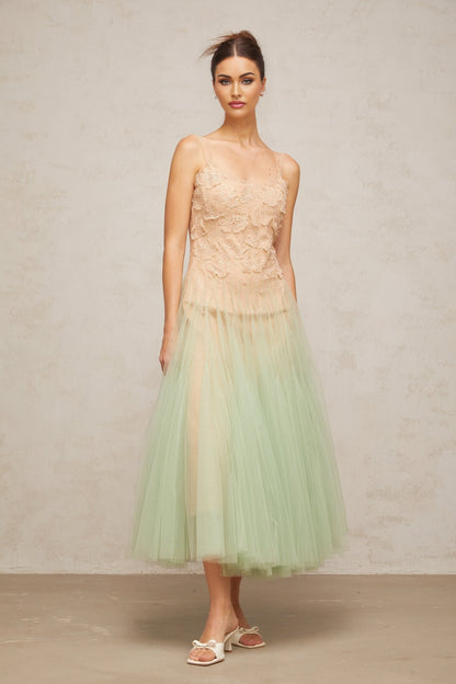 A green midi dress with lace panels and tulle fabric featuring a feminine silhouette and delicate details