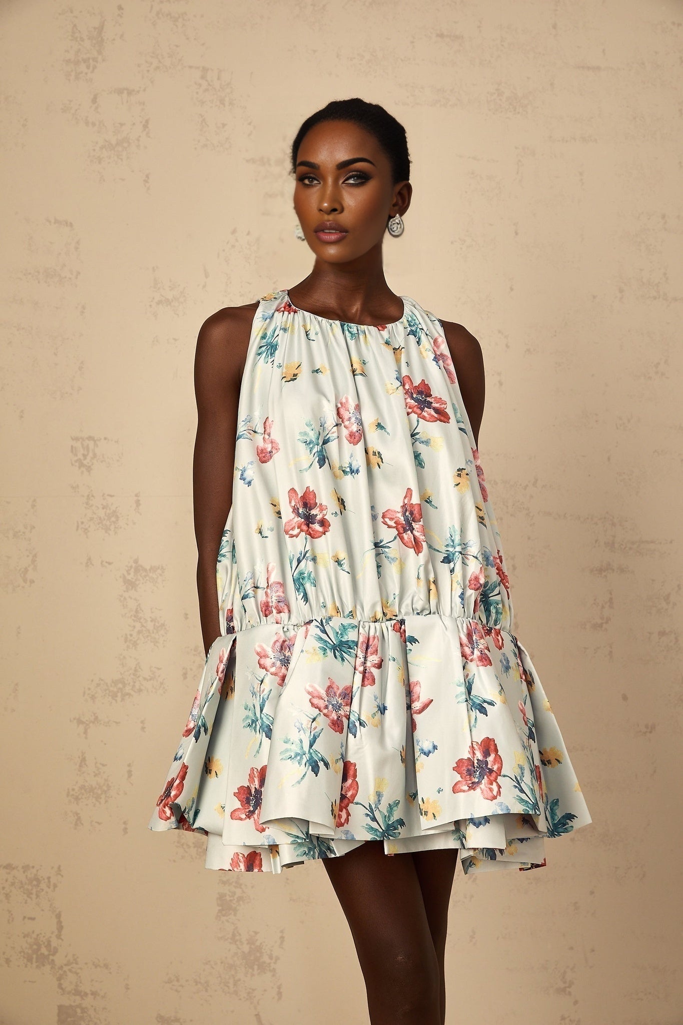 A green mini dress with a floral print pattern and shirred detailing called Wendy