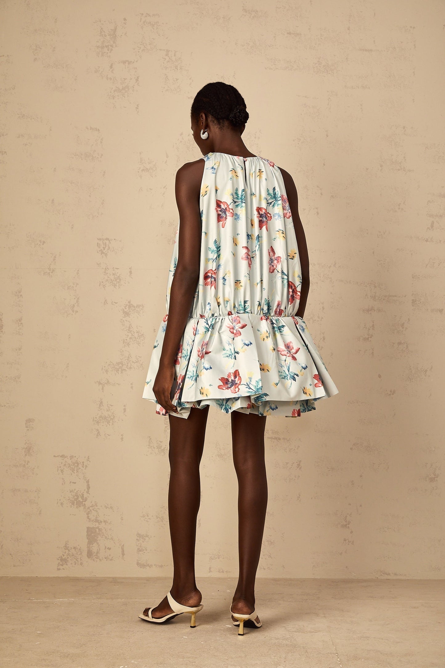 A green mini dress with floral print pattern and shirred fabric featuring a Wendy design