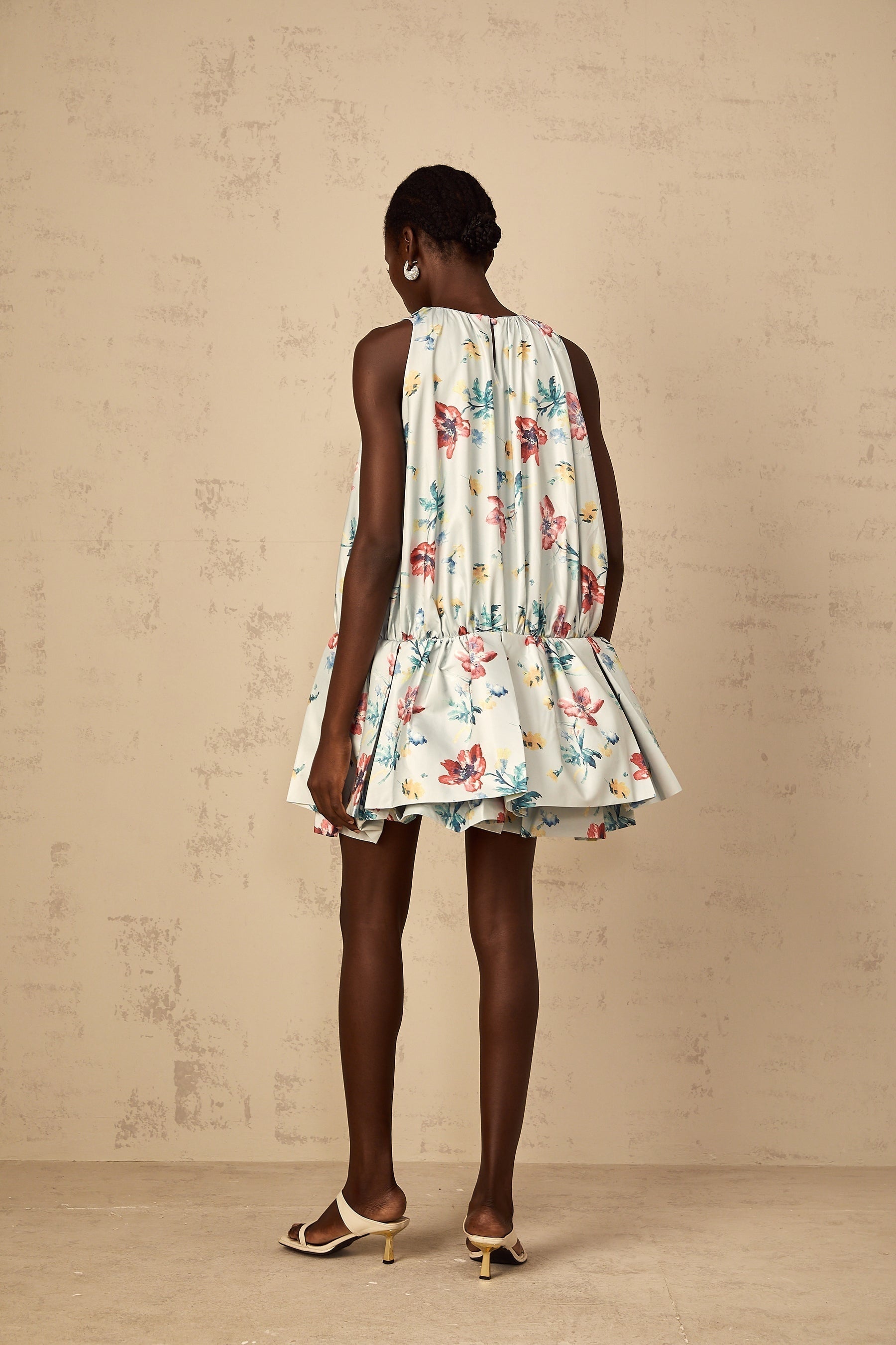 A green mini dress with floral print pattern and shirred fabric featuring a Wendy design