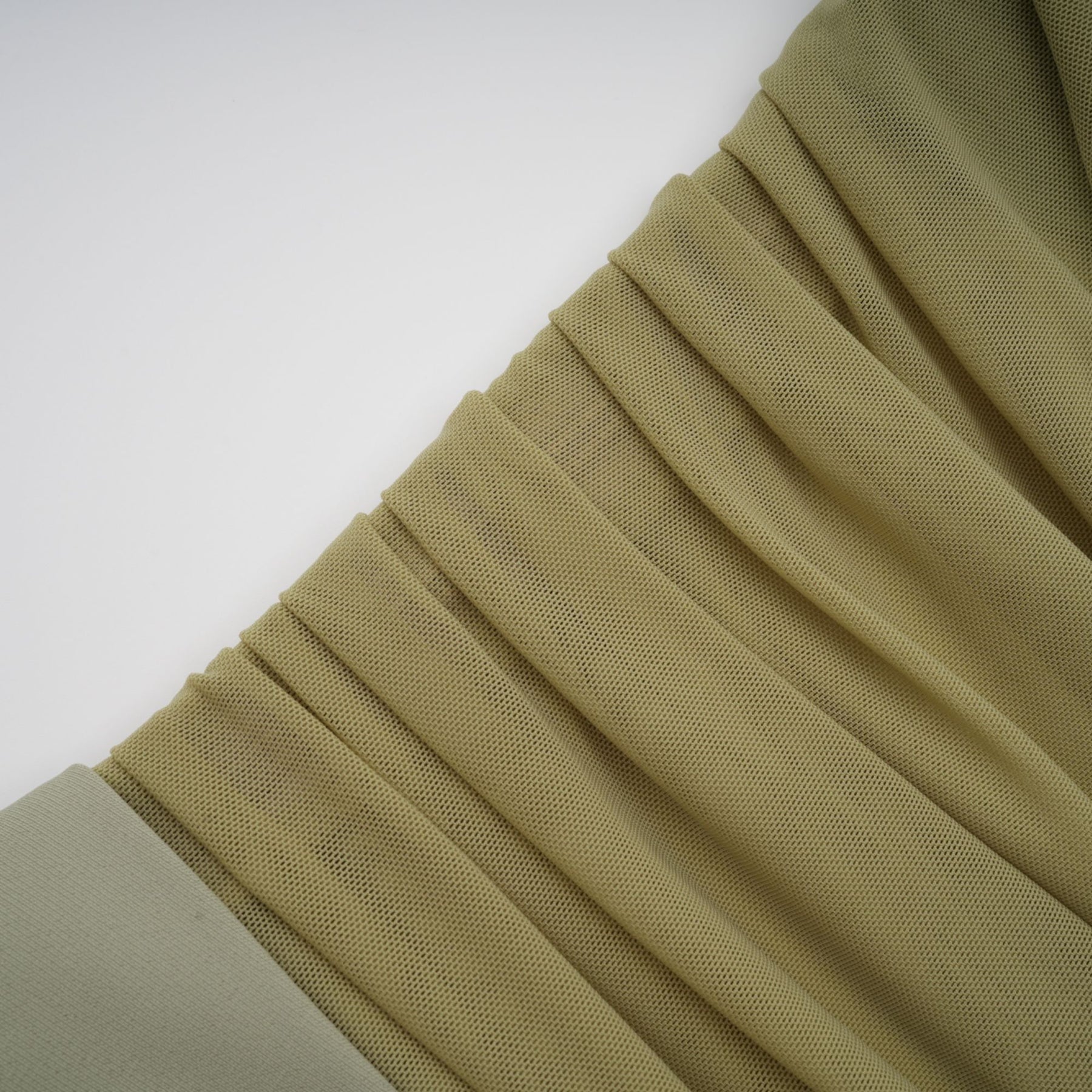 A green offshoulder midi dress with a semisheer design modeled on a female figure against a plain background