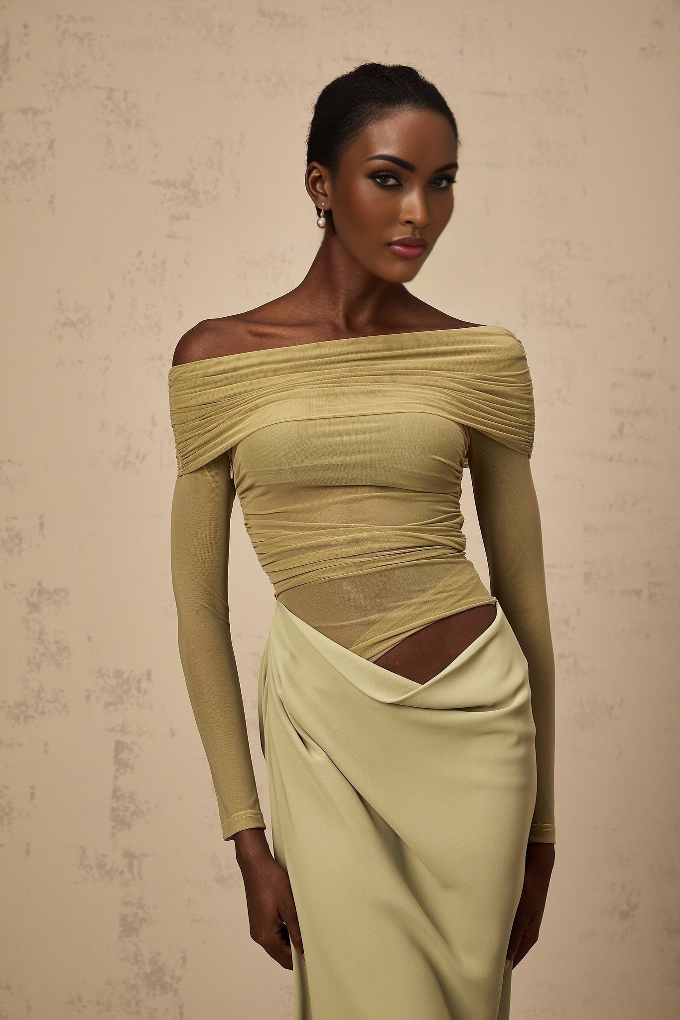 A green offshoulder midi dress with a semisheer fabric shown on a model against a plain background