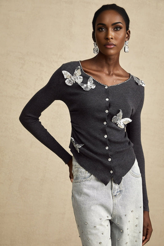 A grey cardigan with sequined butterfly designs adorning the fabric