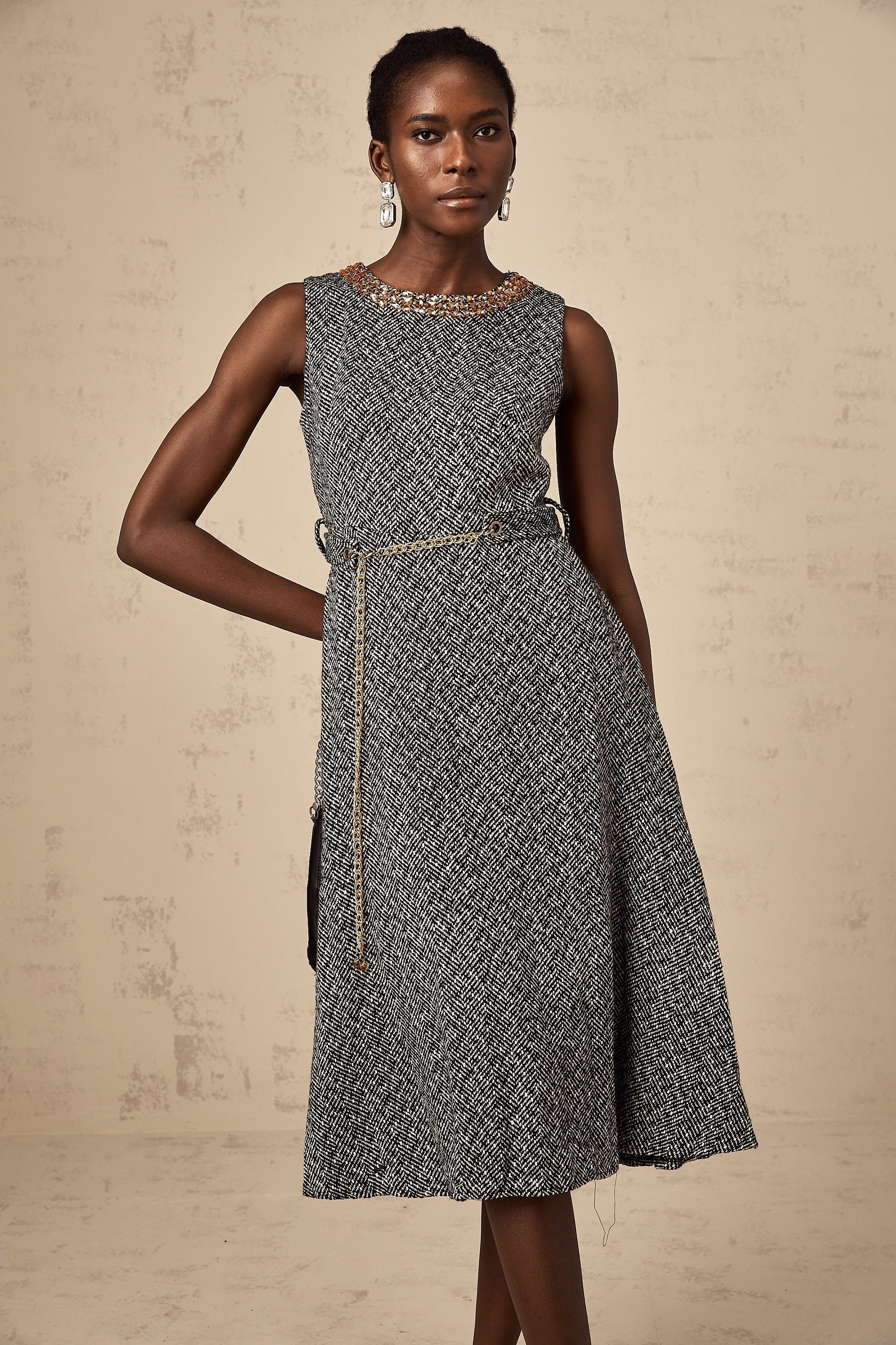 A grey sleeveless tweed midi dress with crystal embellishments suitable for Valentines Day occasion featuring a fitted silhouette and textured fabric