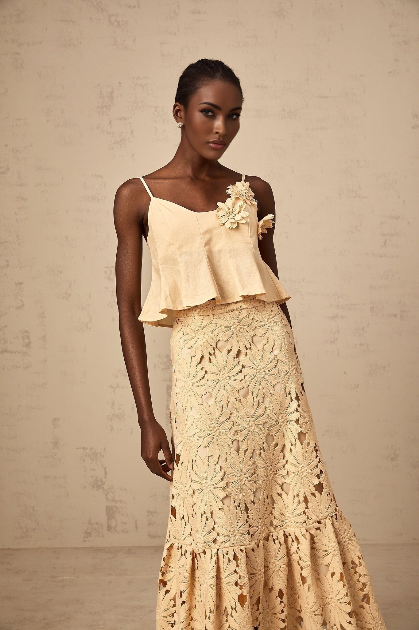 A khaki colored matching set consisting of a flared top with cut out details and a coordinating skirt from Celine