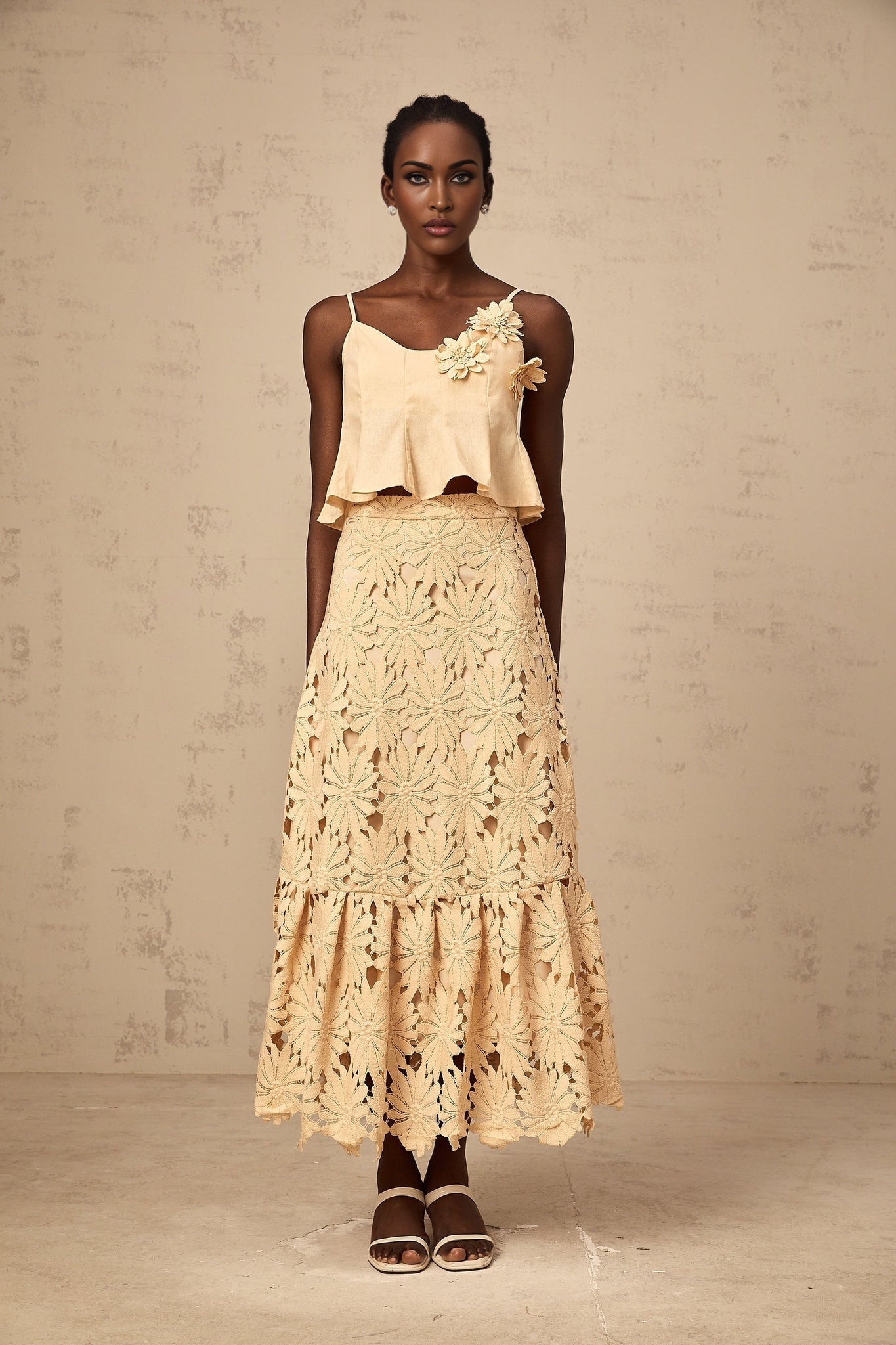 A khaki colored matching set consisting of a flared top with cutout details and a coordinating skirt designed by Celine
