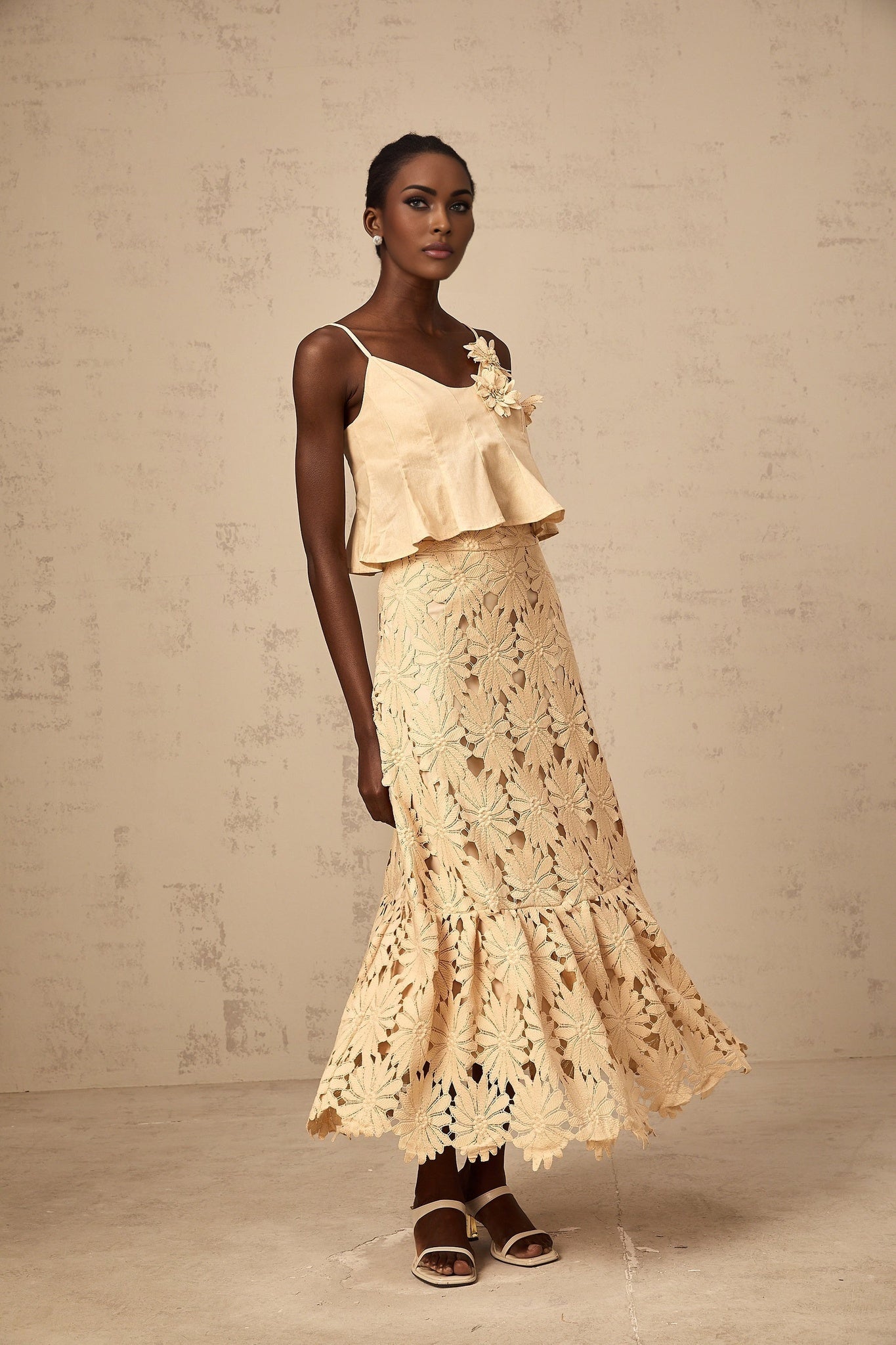 A khaki colored matching set featuring a flared top with cut out details and a coordinating skirt from Celine