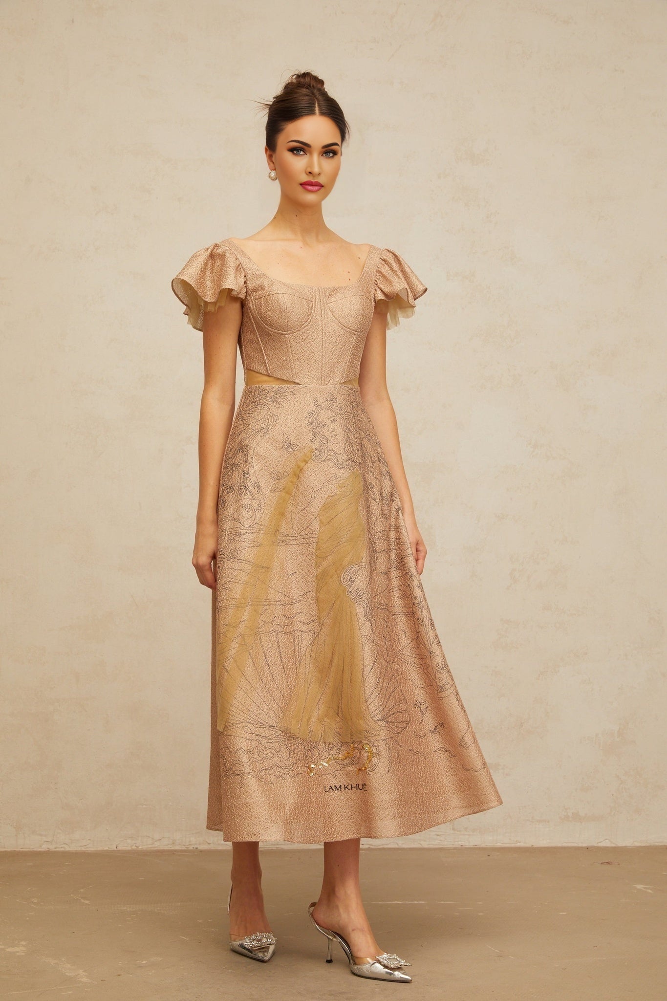 A khaki colored midi dress with a flared skirt featuring a graphic print design named Giada