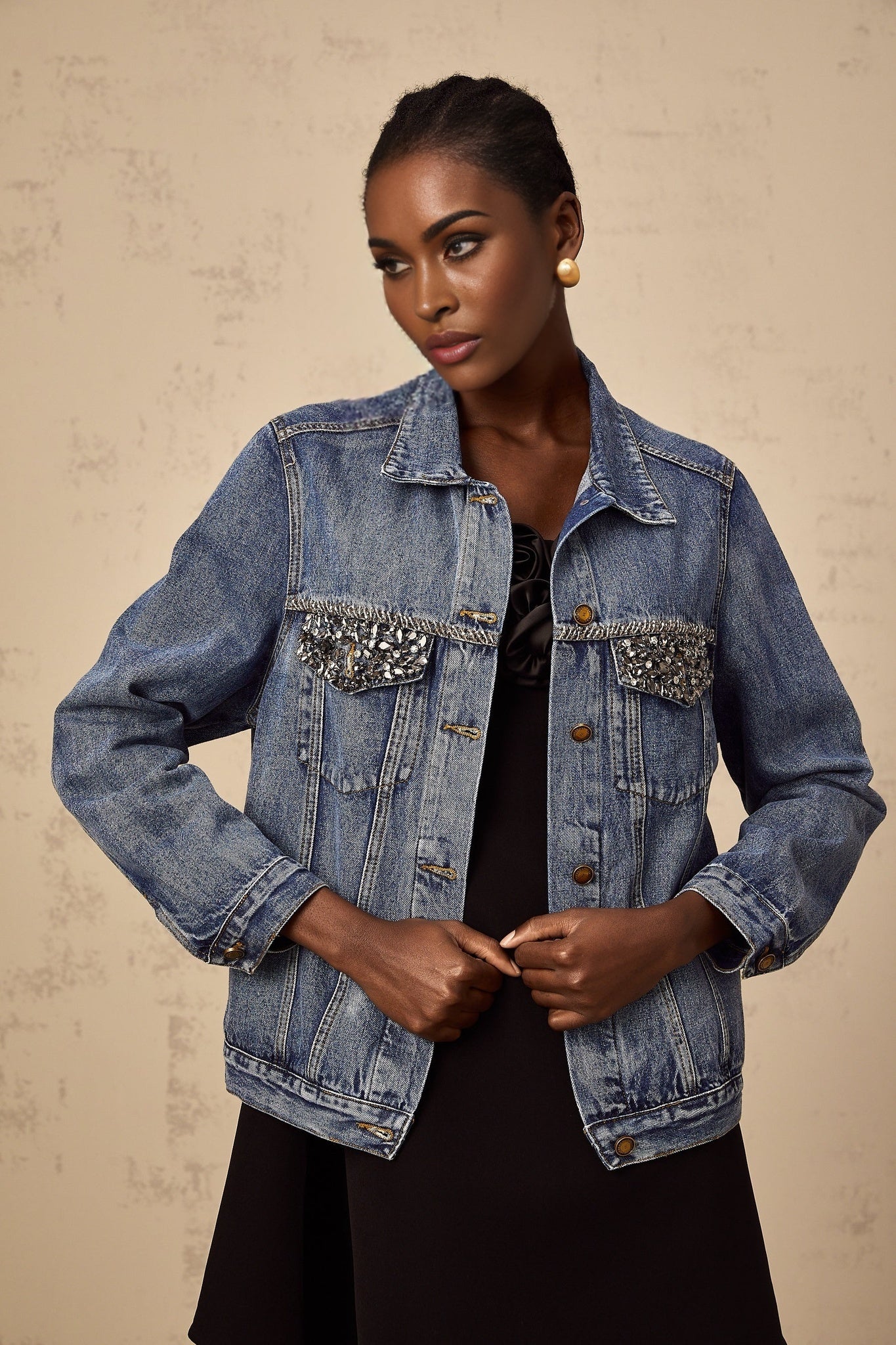 A light blue denim jacket adorned with sparkling rhinestones featuring a feminine and glamorous design