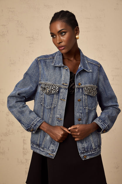A light blue denim jacket adorned with sparkling rhinestones featuring a feminine and glamorous design