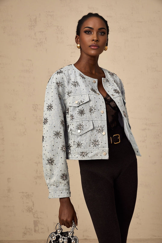 A light blue denim jacket with sun motif studs decorating the front and sleeves Katell branded design with distressed details