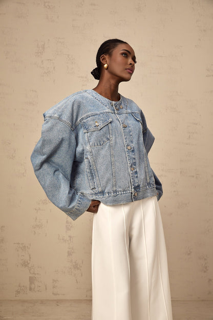A light blue denim jacket without a collar worn by a female model