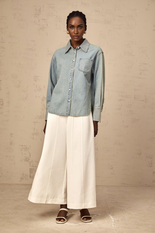 A light blue denim shirt adorned with sparkling rhinestones arranged in decorative patterns across the fabric