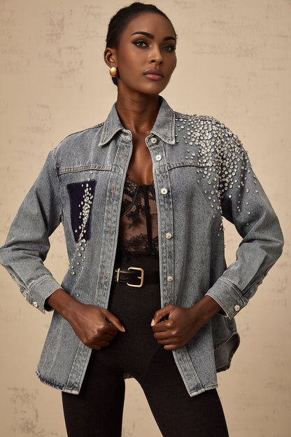 A light blue denim shirt with rhinestone embellishments scattered across the fabric featuring a classic collar and button front closure
