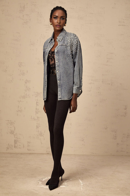 A light blue denim shirt with sparkling rhinestone embellishments scattered across the fabric creating a glamorous and eyecatching design