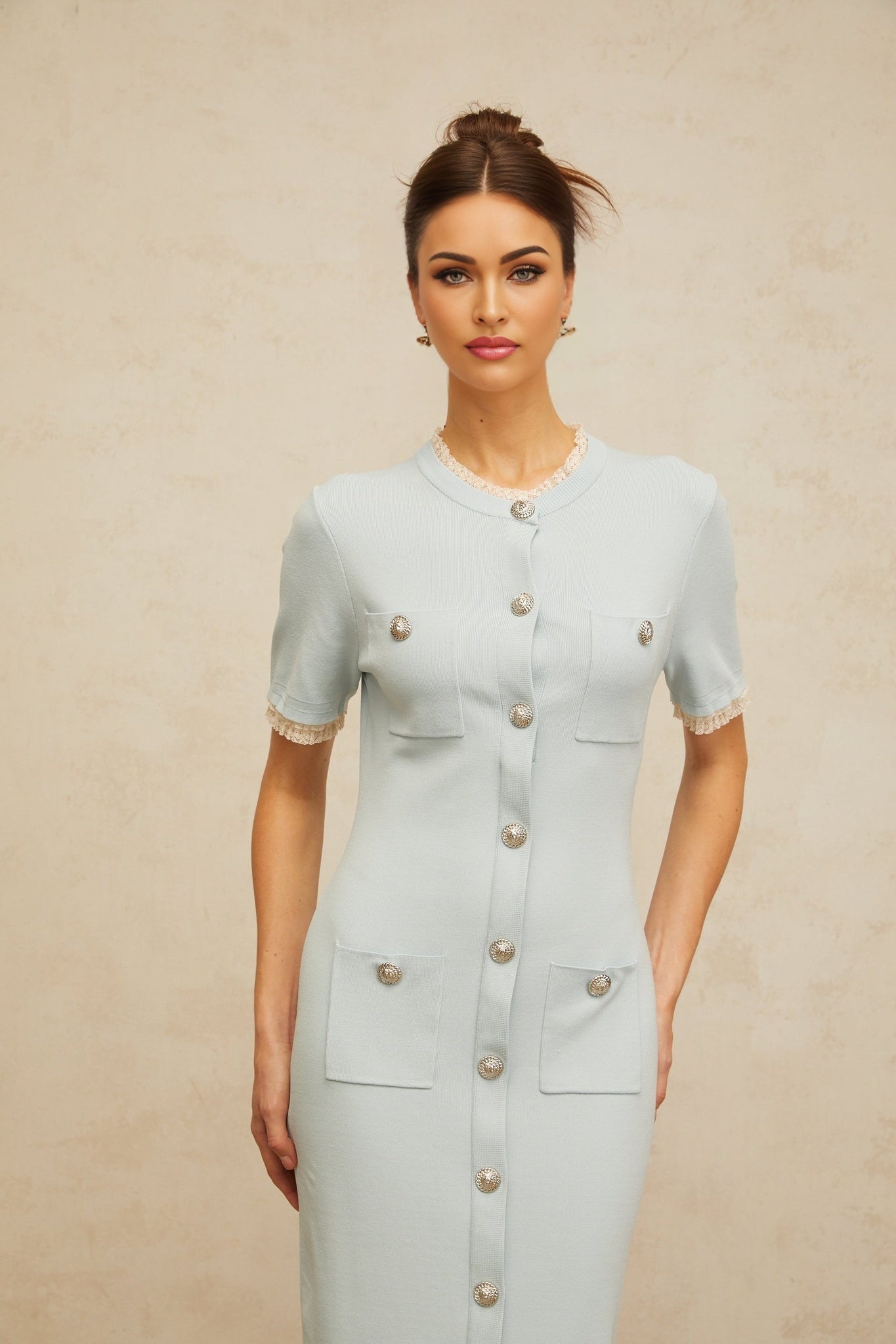 A light blue knit midi dress with a pencil silhouette on a mannequin or model showing the fitted shape and texture of the fabric