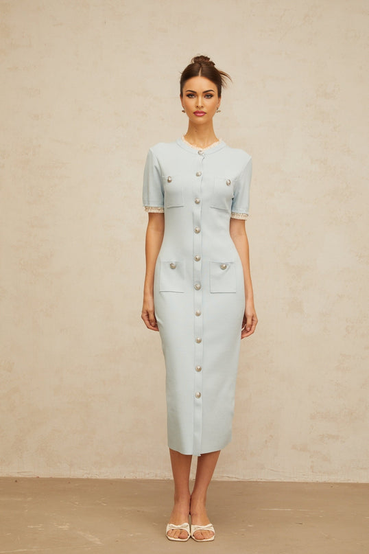 A light blue knit midi dress with a pencil silhouette worn by a model standing against a plain background