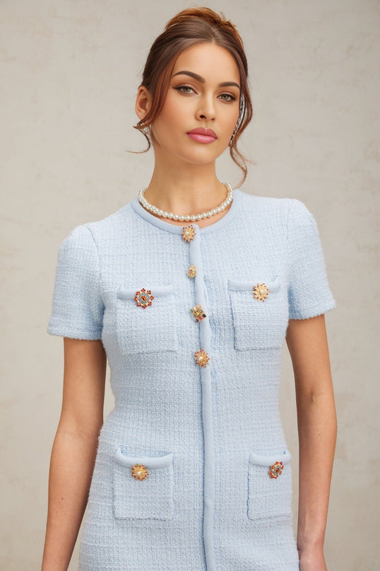 A light blue knit mini dress adorned with sparkling crystal embellishments featuring a form fitting silhouette and short hemline